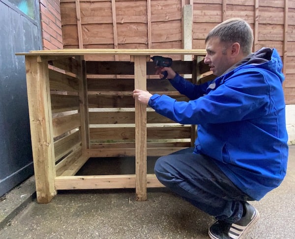 Screwing 75mm screws into log store to secure roof with Bosch PSR Select cordless screwdriver