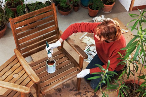 Lady adding a protective layer of oil to loveseat