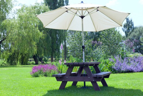 Garden picnic table with parasol in centre hole