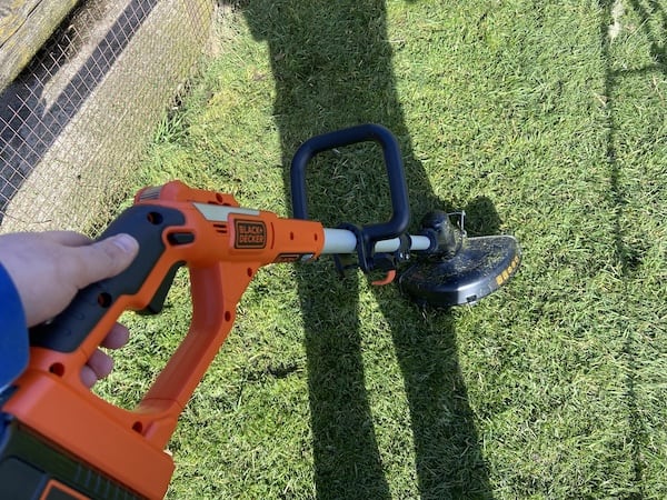 Black + decker cordless strimmer in use