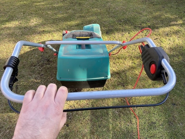 Double handle on the Verticutter Lawnraker which needs to be pressed to use the scarifier