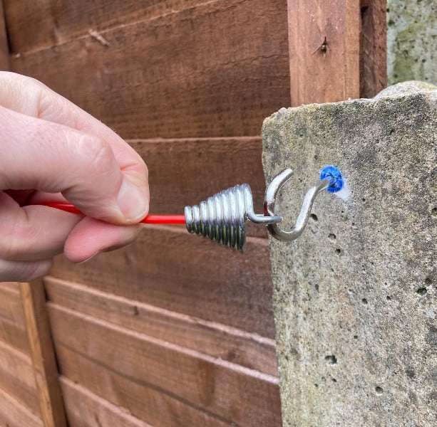 Hook which is included which I screwed into a concrete fence pillar after drilling hole and inserting raw plug, also included