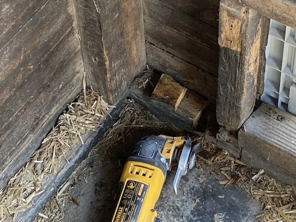 DeWalt DWE315KT Oscillating Multi-Tool with attach fitted being used it cut into shed beam to make space for steel bolt