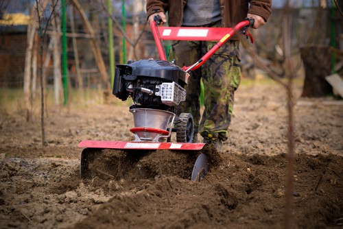 Petrol rotavator preparing soil and tips