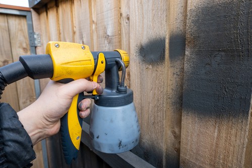 Paint sprayer being use to paint fence