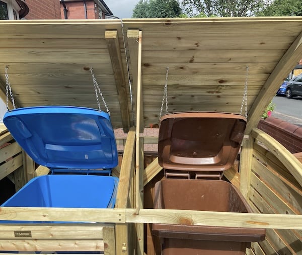 Wheelie bin store with chains to open lids