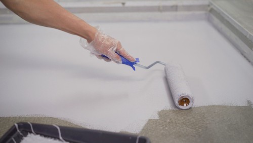 Painting small garage floor with a small hand roller