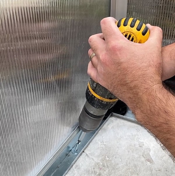 Screwing base to the patio but also using a washer to help prevent the screw head from being pulled through the thin aluminium base