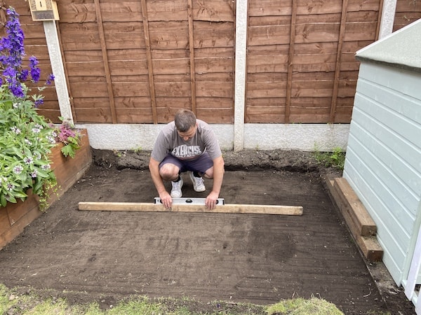 Tamping down to make sure the ground is level before adding dry mix base