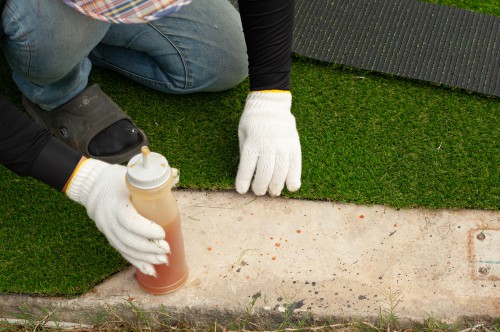 Preparing ground for artificial grass and fastening it down with glue