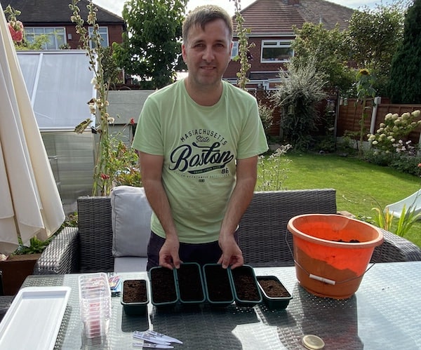 Seed trays filled with seed compost ready for sowing winter pansy seeds