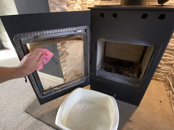 Cleaning glass on wood burning stove with soap and water