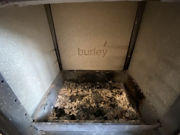 I always leave a layer of ash in the bottom of my wood burning stove as this helps protect the stove and the fire light and burn easier.