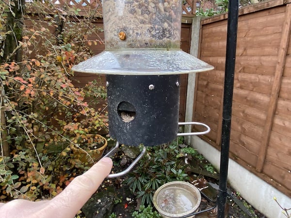 Pigeon and pest proof bird feeder with specially designed hopper that closes on heavier birds such as pigeons.