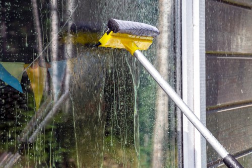 Window cleaning pole with built in squeegee