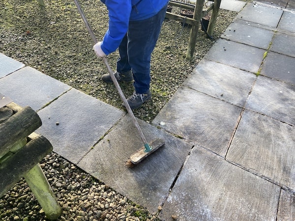 Brushing Smartseal Extreme patio cleaner into paving flags