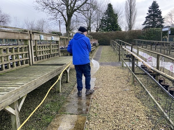 Hosing down flags ready to spray with Xtreme patio cleaner