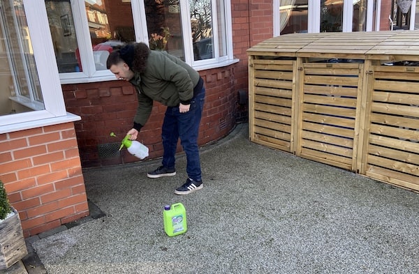 Spraying algon by sprayer onto drive to kill moss and algae