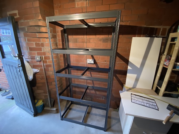 Steel storage rack almost fully assembled, smooth grey frame which is stable.