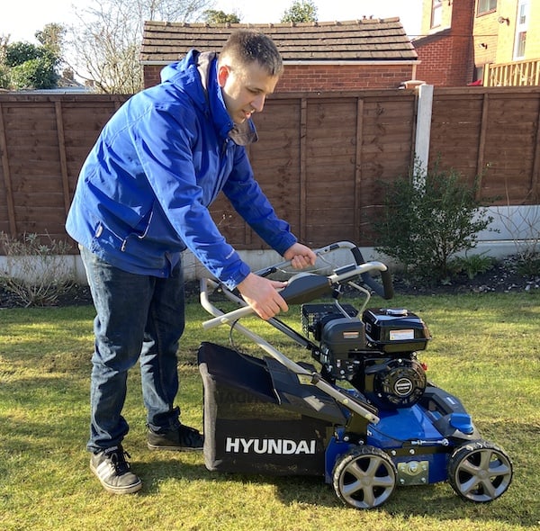 Showing that the handles on the Hyundai scarifier fold down flat to make the machine more compact for storage