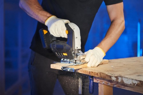 Cordless jigsaw being used to cut angled cuts in wood