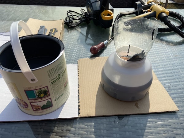 Pouring Cuprinol garden shades paint into sprayer tank using funnel made from coke bottle