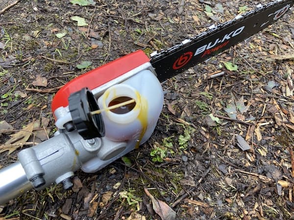 Putting oil in the oil tank on the chainsaw attachment