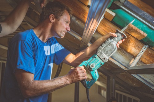 Reciprocating saw being used to cut floor boards