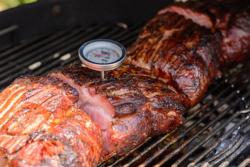 With thermometer meat temperature is checked at the kettle grill