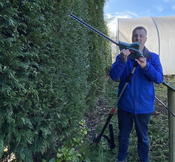 showing how the hedge trimmer head can rotate 90 degrees to trim the top of hedges