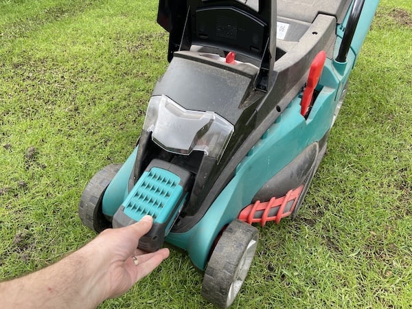 Inserting battery into cordless lawn mower