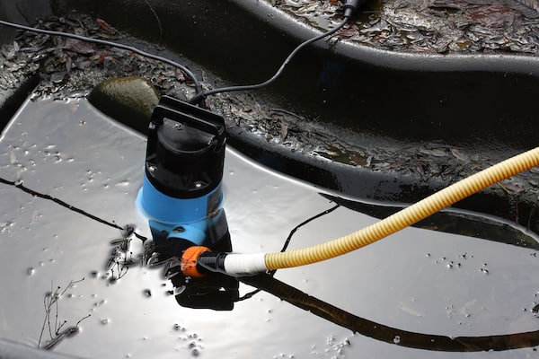 Using dirty water pump to empty water and deep clean pond