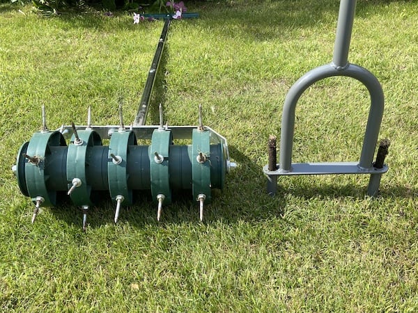 Two types of lawn aerator, spiked aertaor on a roller and a hollow tine aerator that removes cores from the lawn